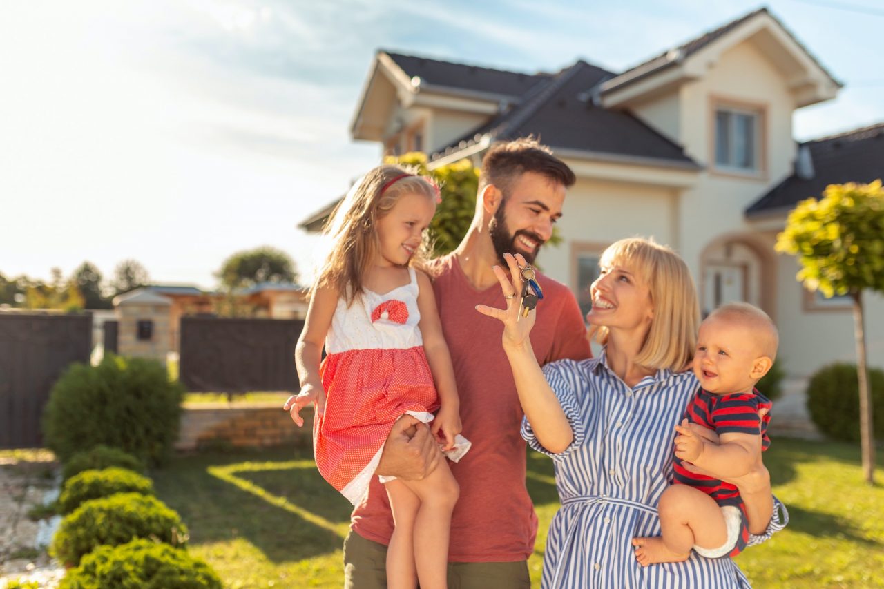 Family holding keys after buying their new home.