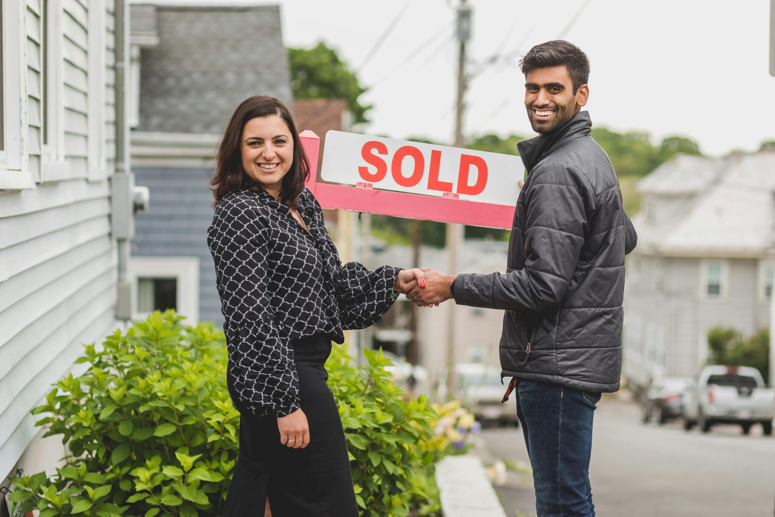 Home sellers excited and holding their sold sign